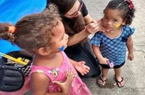Criança recebendo pintura facial durante a feira do Dia das Crianças