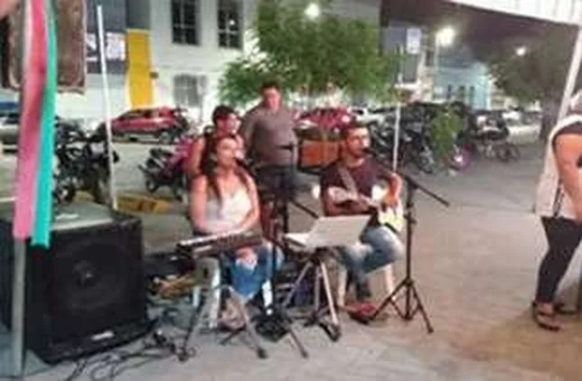 Apresentação de música ao vivo durante uma edição da feira, com músicos sob a tenda